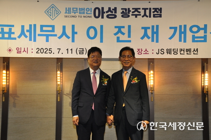 김성후 광주지방세무사회장이 이진재 세무사에게 세무사 배지를 패용한 후 기념촬영을 하고 있다.