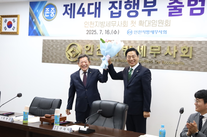 최병곤 회장이 한국세무사회 제34대 회장 연임을 축하하며 구재이 본회장에게 축하의 꽃다발을 전달하고 있다.