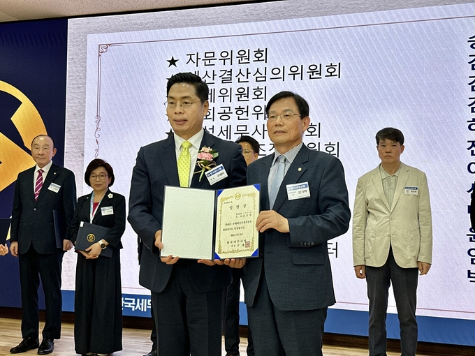구재이 세무사회장이 신기탁 손해배상공제위원장에게 임명장을 수여하고 있다. 