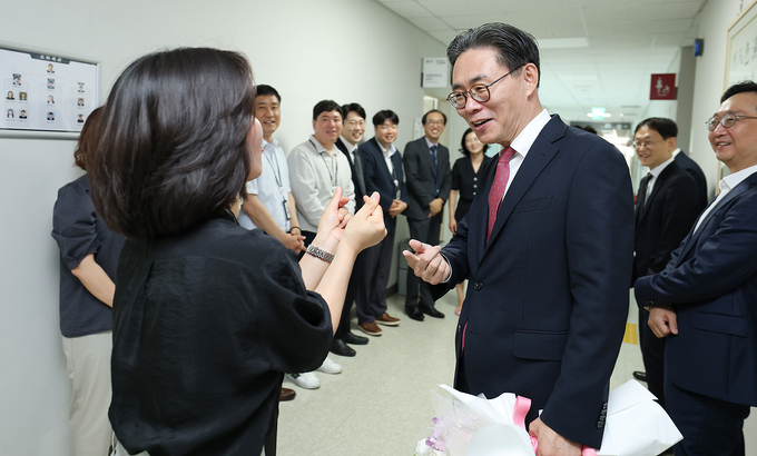 한 여직원이 퇴임하는 강민수 청장에게 손하트로 작별인사를 하고 있다.