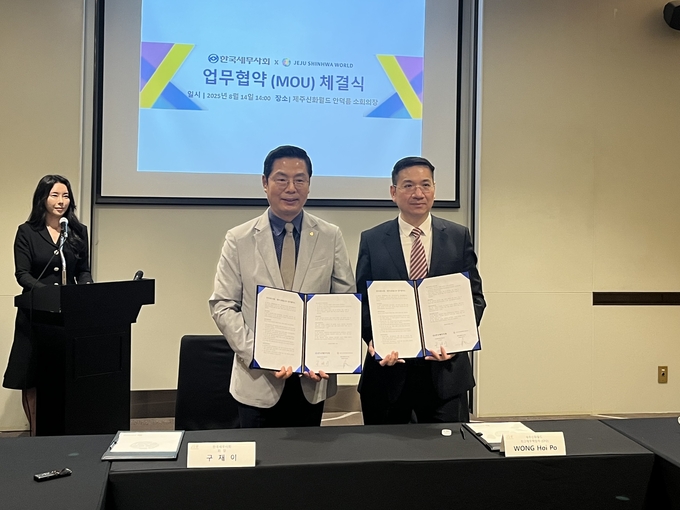 구재이 한국세무사회장과 제주신화월드 WONG Hoi Po CFO가 업무협약을 체결하고 있다. 