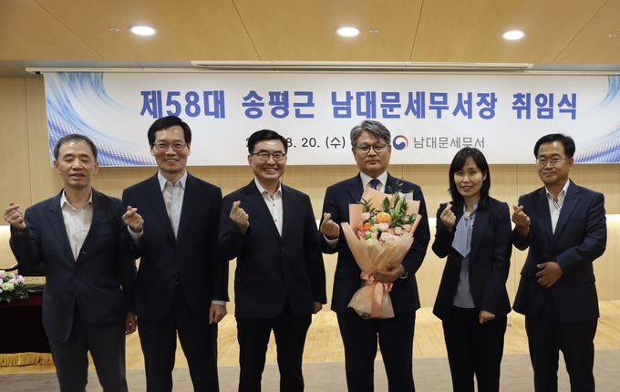 송평근<오른쪽 세번째> 신임 남대문세무서장이 취임식 후 축하 꽃다발을 안고 과장들과 기념촬영하고 있다. 