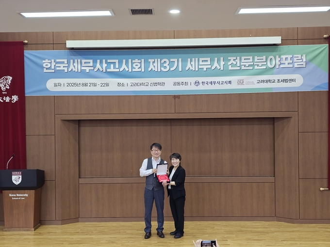 장보원 회장(왼쪽)이 '글로벌기업의 이전가격 관리방안'을 발표란 양은진 세무사에 최우수사례 시상을 하고 있다.