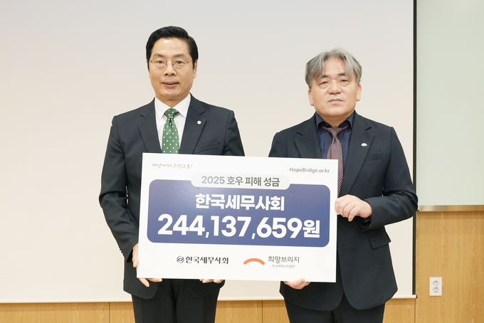 구재이 한국세무사회장이 희망브리지 전국재해구호협회에 성금을 전달하고 있다. 
