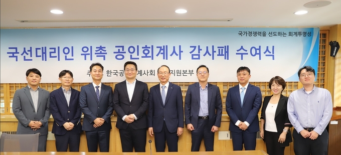 한국공인회계사회관에서 열린 '국선대리인 위촉 공인회계사 감사패 수여식'에서 최운열 회장(왼쪽 다섯번째)과 국선대리인으로 참여한 공인회계사들이 기념촬영을 하고 있다.