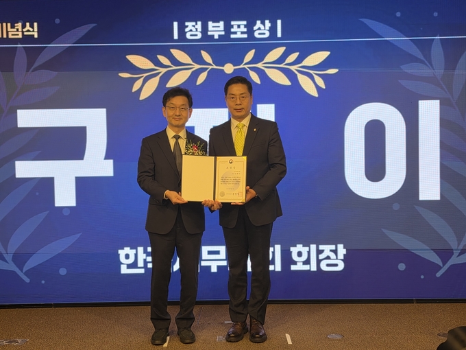 윤창렬 국무조정실장(왼쪽)이 구재이 한국세무사회장에게 정부포상을 수여 후 기념촬영하고 있다.