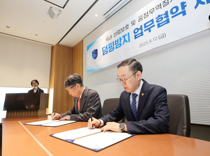 이명구 관세청장<오른쪽>)이 12일 무역협회에서 국내산업 보호 및 공정무역질서 확립을 위해 무역위원회와 업무협약을 체결하고 있다.<사진=관세청>