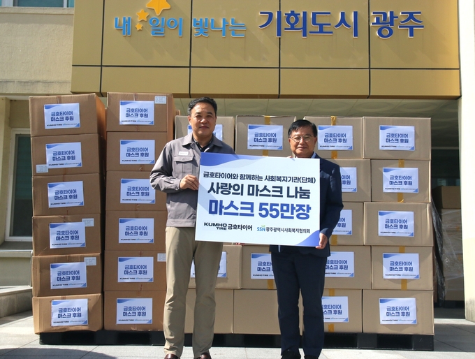 금호타이어 황호길 G.생산운영본부장(왼쪽)과 김영기 광주사회복지협의회장이 마스크 전달식 후 기념촬영을 하고 있다.