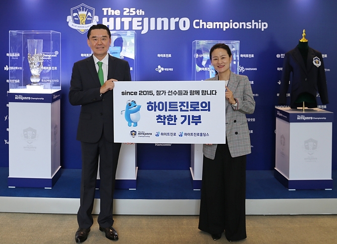 김인규 하이트진로 대표이사(왼쪽)가 지난 28일 ‘제25회 하이트진로 챔피언십’에서 장영미 성동나래주간보호센터장과 이동차량 지원사업 기부금 전달식 기념촬영을 하고 있다. 