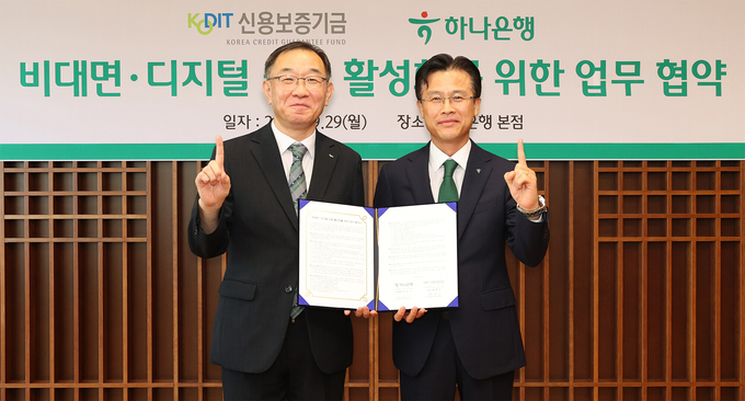 하나은행은 지난 29일 본점에서 신용보증기금과 '비대면·디지털 금융 활성화를 위한 업무협약'을 체결했다. 이날 협약식에 참석한 서유석 하나은행 기업그룹 부행장(사진 오른쪽)과 채병호 신용보증기금 이사가 기념 촬영을 하고 있다.