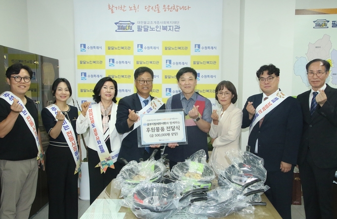 왼쪽부터 진성구 동수원지역회 간사, 유수진 동수원지역회장, 김미자 홍보이사, 이재실 회장, 윤학수 노인복지관 관장 및 관계자, 양헌태 수원지역회 간사, 박종명 사무국장이 후원물품 전달 후 기념활영하고 있다. 