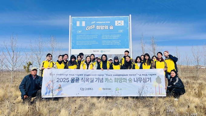 30여 명의 봉사단이 몽골 식목일을 기념해 ‘카스 희망의 숲’ 나무심기 봉사활동을 마치고 기념촬영을 하고 있다.<사진=오비맥주>