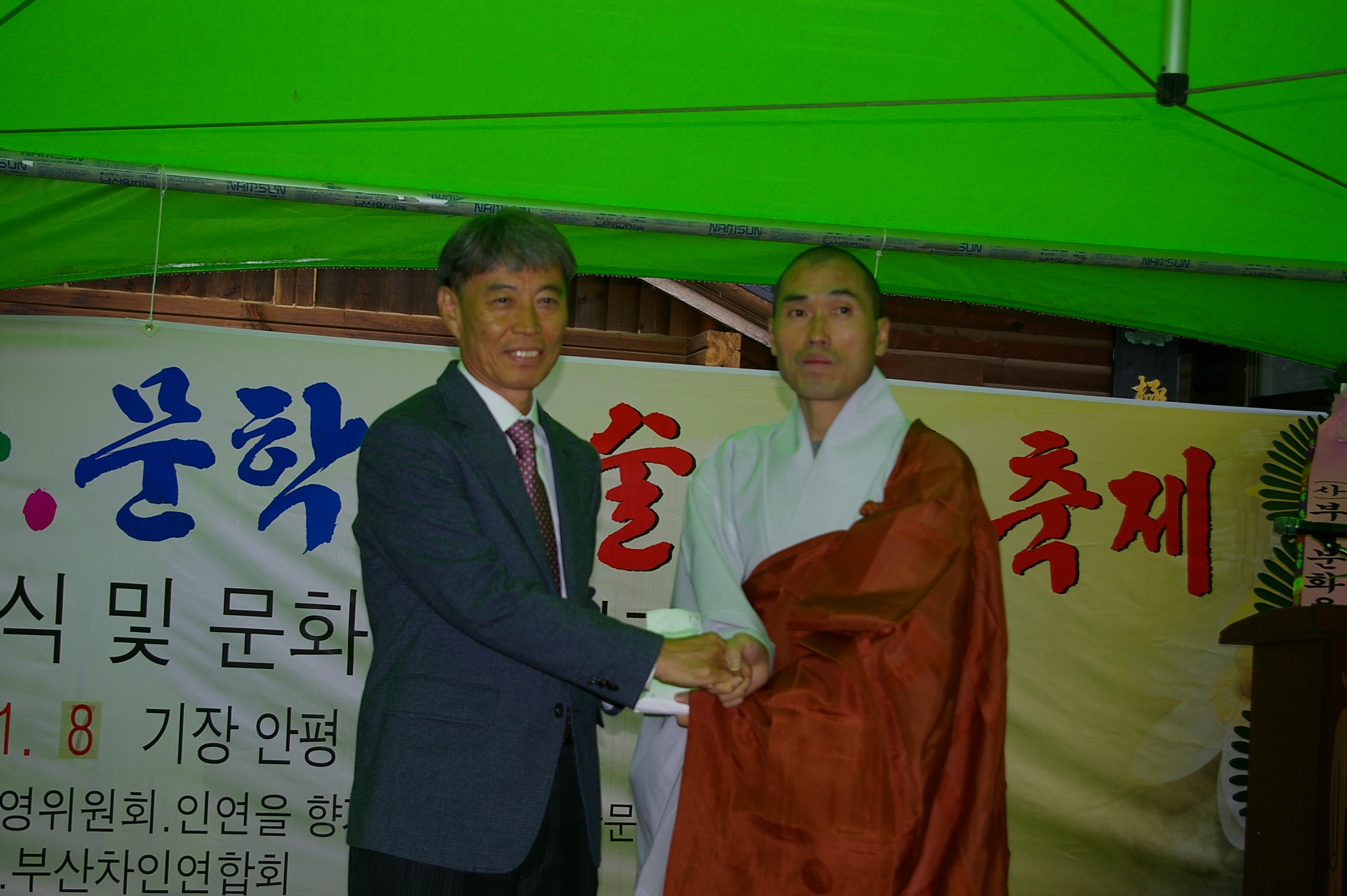 장안사 주지 정오 스님(사진 오른쪽)이 황구 기장문화원향토연구소장에게 청량문화 격려금을 전달하고 있다.