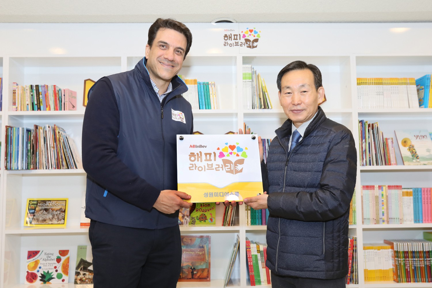 오비맥주 김도훈 대표(왼쪽)가 성원미디어스쿨 지역아동센터 임동채 센터장(오른쪽)에게 현판을 전달하고 있다.
